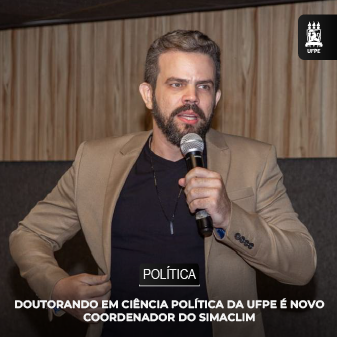 Foto do Doutorando Hugo Mariz com microfone na mão.